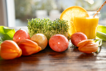 Easter eggs and fresh cress decorated on wooden table for healthy easter breakfast with orange...