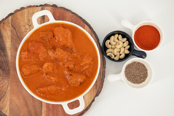 Tasty butter chicken curry dish from Indian cuisine. Tasty butter chicken curry, Murg Makhanwala or masala. Butter chicken tikka masala served with roti / Paratha and plain rice along with onion salad