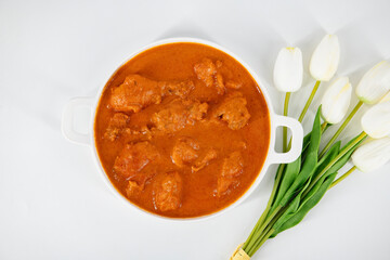Tasty butter chicken curry dish from Indian cuisine. Tasty butter chicken curry, Murg Makhanwala or masala. Butter chicken tikka masala served with roti / Paratha and plain rice along with onion salad