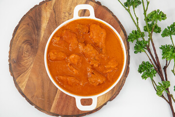 Tasty butter chicken curry dish from Indian cuisine. Tasty butter chicken curry, Murg Makhanwala or masala. Butter chicken tikka masala served with roti / Paratha and plain rice along with onion salad