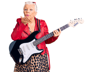 Senior beautiful woman with blue eyes and grey hair wearing a modern look playing electric guitar looking at the camera blowing a kiss with hand on air being lovely and sexy. love expression.