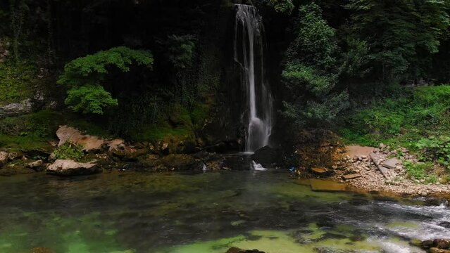 Abhesi waterfall among green trees, a mountain river with clear water. the stones are turned by the stream. Tourist place for rest and swimming. Aerial view. western Georgia 