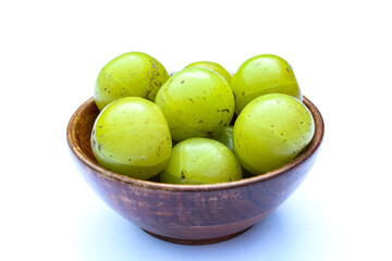 Phyllanthus emblica or Indian gooseberry fruits in a wooden bowl 