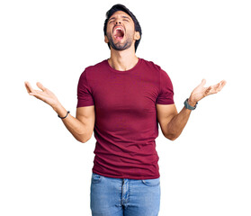 Handsome hispanic man wearing casual clothes crazy and mad shouting and yelling with aggressive...