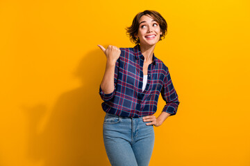Photo of satisfied woman with short hairdo dressed plaid shirt look directing at sale empty space...