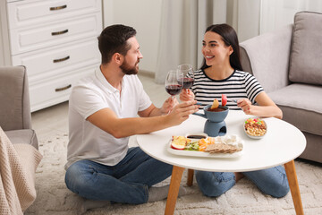 Affectionate couple enjoying chocolate fondue during romantic date at home