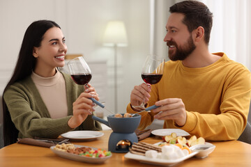 Affectionate couple enjoying chocolate fondue during romantic date at home