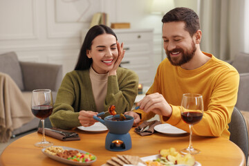 Affectionate couple enjoying chocolate fondue during romantic date at home