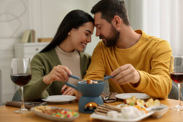 Romantic date with fondue. Couple enjoying each other at home