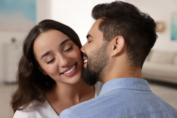 Cute couple. Man kissing his girlfriend at home