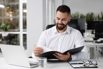 Obraz premium Smiling man working at table in office. Lawyer, businessman, accountant or manager