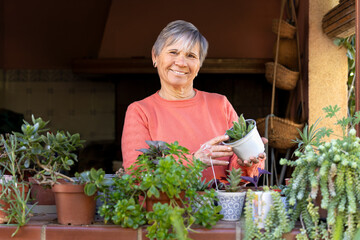 Woman looking at the camera with a satisfied expression, showcasing a small cactus
