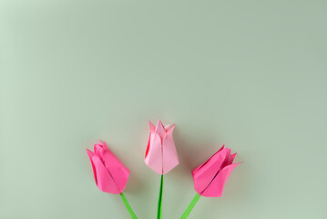 Handmade tulips made of pink paper on a green background. Mother's day, women's day concept.