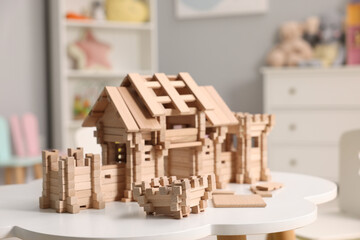 Wooden entry gate and building blocks on white table indoors. Children's toy