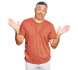 Handsome middle age man wearing casual clothes clueless and confused expression with arms and hands...