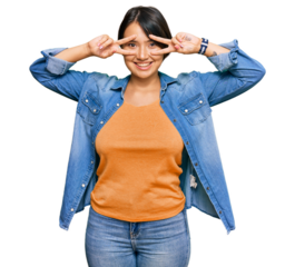Young beautiful hispanic woman with short hair wearing casual denim jacket doing peace symbol with fingers over face, smiling cheerful showing victory