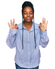 Young african american woman wearing casual clothes relax and smiling with eyes closed doing meditation gesture with fingers. yoga concept.