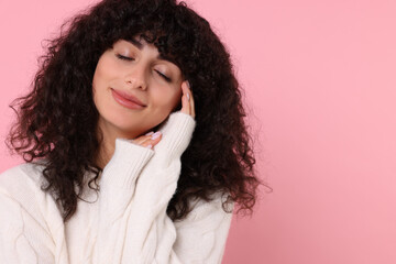 Young woman in stylish white sweater on pink background, space for text