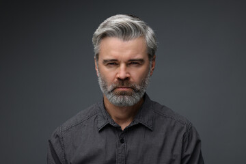Personality concept. Portrait of emotional man on dark grey background