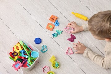 Cute little boy playing on warm floor indoors, above view. Heating system