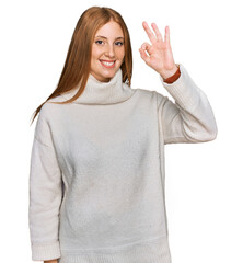 Young irish woman wearing casual winter sweater smiling positive doing ok sign with hand and fingers. successful expression.