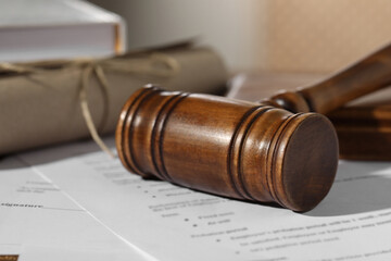 Notary contract. Wooden gavel and documents on table, closeup