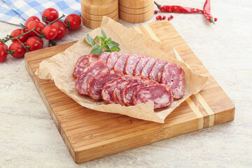 Sliced salami sausages over board