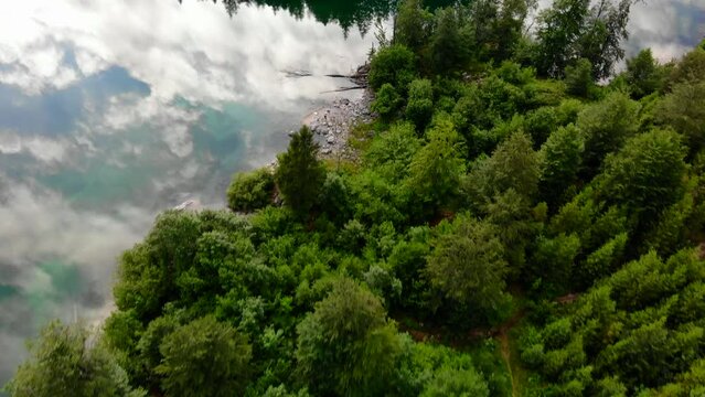 Drohnenflug &uuml;ber dem See mit Wald und Bergen
