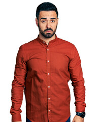 Young hispanic man with beard wearing casual shirt skeptic and nervous, frowning upset because of problem. negative person.
