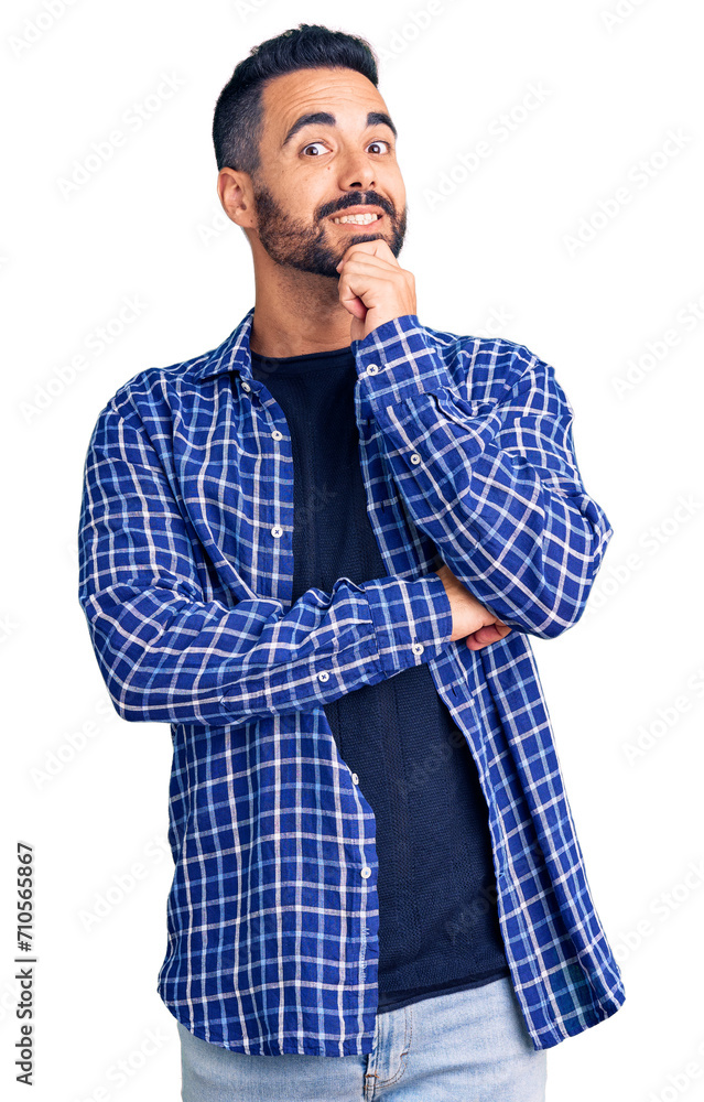 Canvas Prints Young hispanic man wearing casual clothes looking confident at the camera smiling with crossed arms and hand raised on chin. thinking positive.