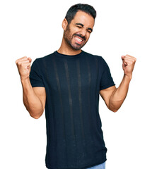 Young hispanic man wearing casual clothes very happy and excited doing winner gesture with arms...