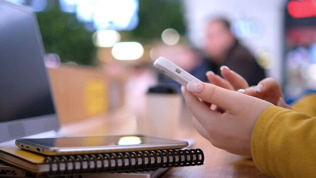 Side view. Hand of girl using texting mobile phone of laptop chat in mall. Close up of young woman hand 4K