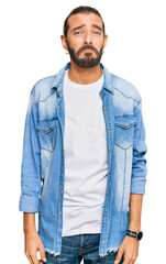 Fototapeta premium Attractive man with long hair and beard wearing casual denim jacket depressed and worry for distress, crying angry and afraid. sad expression.