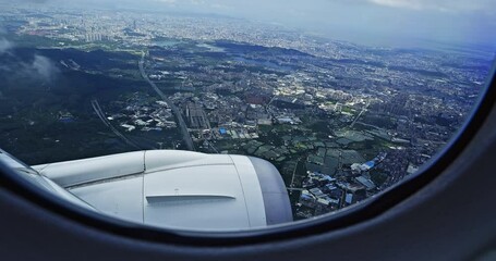 Airplane flight. Wing of an airplane flying above the city skyline. View from the window of the plane. The plane is descending over the city. Traveling by air. 4K real time video. - Powered by Adobe