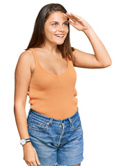 Young caucasian woman wearing casual clothes very happy and smiling looking far away with hand over head. searching concept.