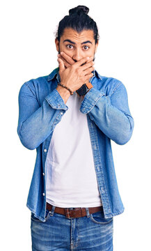 Young arab man wearing casual denim shirt shocked covering mouth with hands for mistake. secret concept.