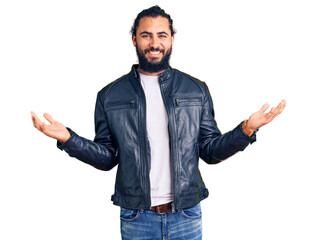 Young arab man wearing casual leather jacket smiling showing both hands open palms, presenting and advertising comparison and balance