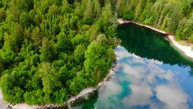 Drohnenflug &uuml;ber dem See mit Wald und Bergen