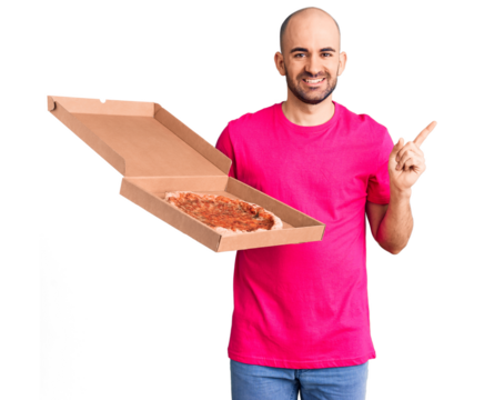 Young handsome man holding delivery pizza cardboard box smiling happy pointing with hand and finger to the side