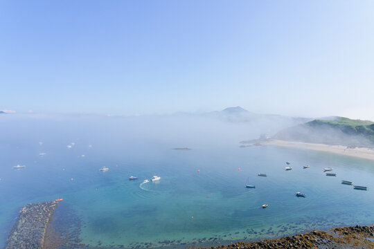 Across the clear waters of Porthdinllaen harbour on a foggy day in June.