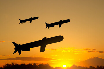 Fototapeta na wymiar Silhouettes of Tomahawk cruise missiles against the sunset