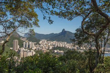 Obraz premium Rio de Janeiro, Brazil. Aerial view of the city framed by the local vegetation. In background, the Corcovado Hill and Christ statue.