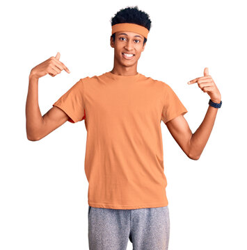 Young african american man wearing sportswear looking confident with smile on face, pointing oneself with fingers proud and happy.