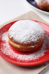 Delicious sweet bun with powdered sugar on table, closeup