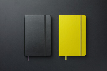 Different notebooks on black background, top view