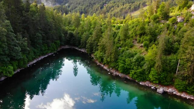 Drohnenflug &uuml;ber dem See mit Wald und Bergen