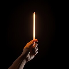 hand holding light stick on black background