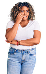 Young african american plus size woman wearing casual clothes looking stressed and nervous with hands on mouth biting nails. anxiety problem.