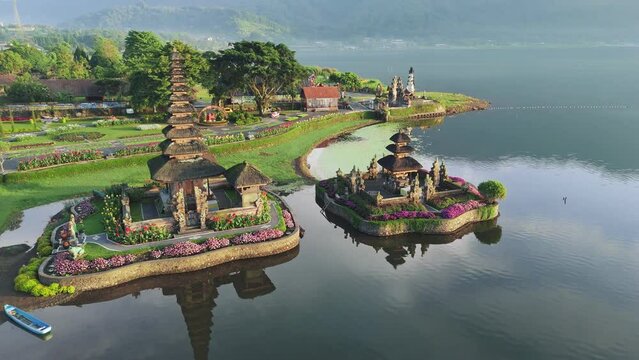 Magnificent Pura Ulun Danu temple decorated with flowers on Bratan lake in Bali, Indonesia. Flying around Pura Ulun Danu temple during the sunrise