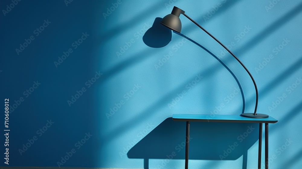 Aufkleber a modern black desk lamp with a curved neck casting a soft shadow on a vibrant blue table and wall, 
